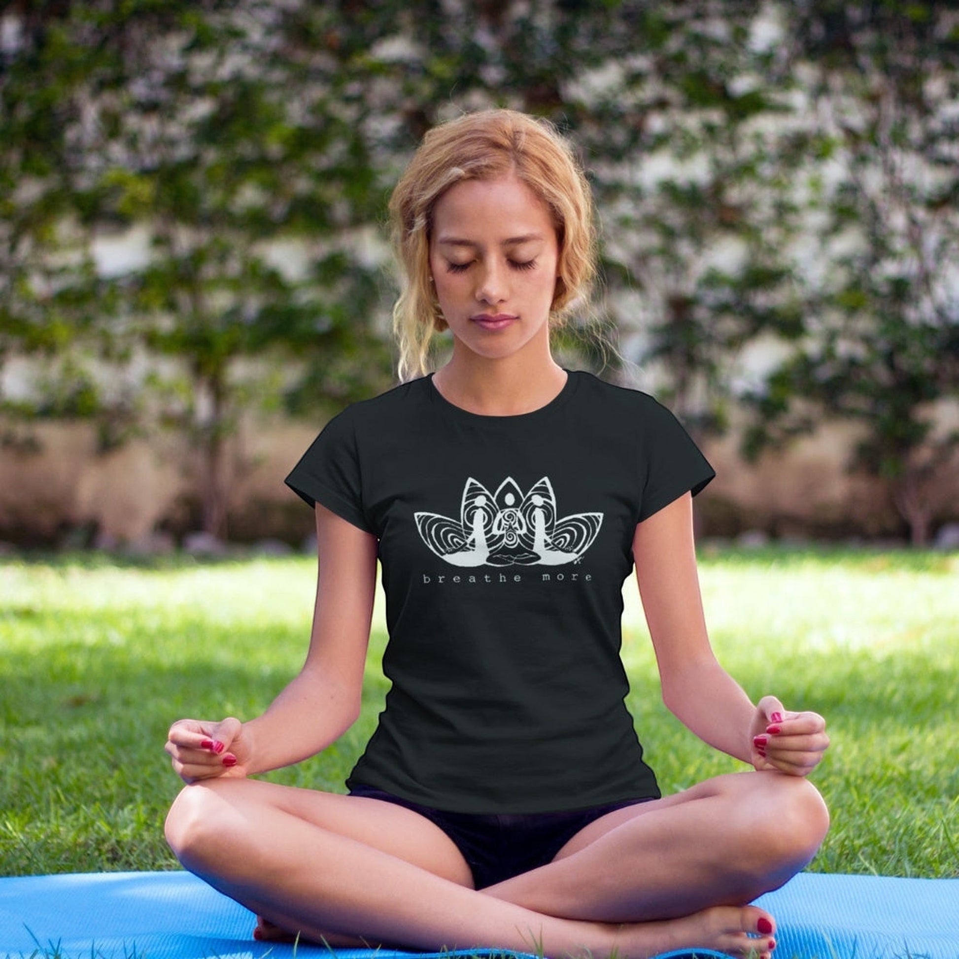 Woman meditating outdoors in black 'Breathe More' Women's Yoga T-Shirt made from Bamboo & Organic Cotton, perfect for mindfulness and yoga.