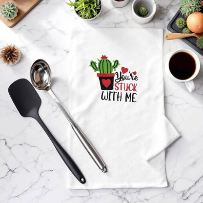 You're Stuck With Me towel with humorous embroidered cactus design, displayed on marble kitchen counter with utensils and coffee. Ideal small gift.