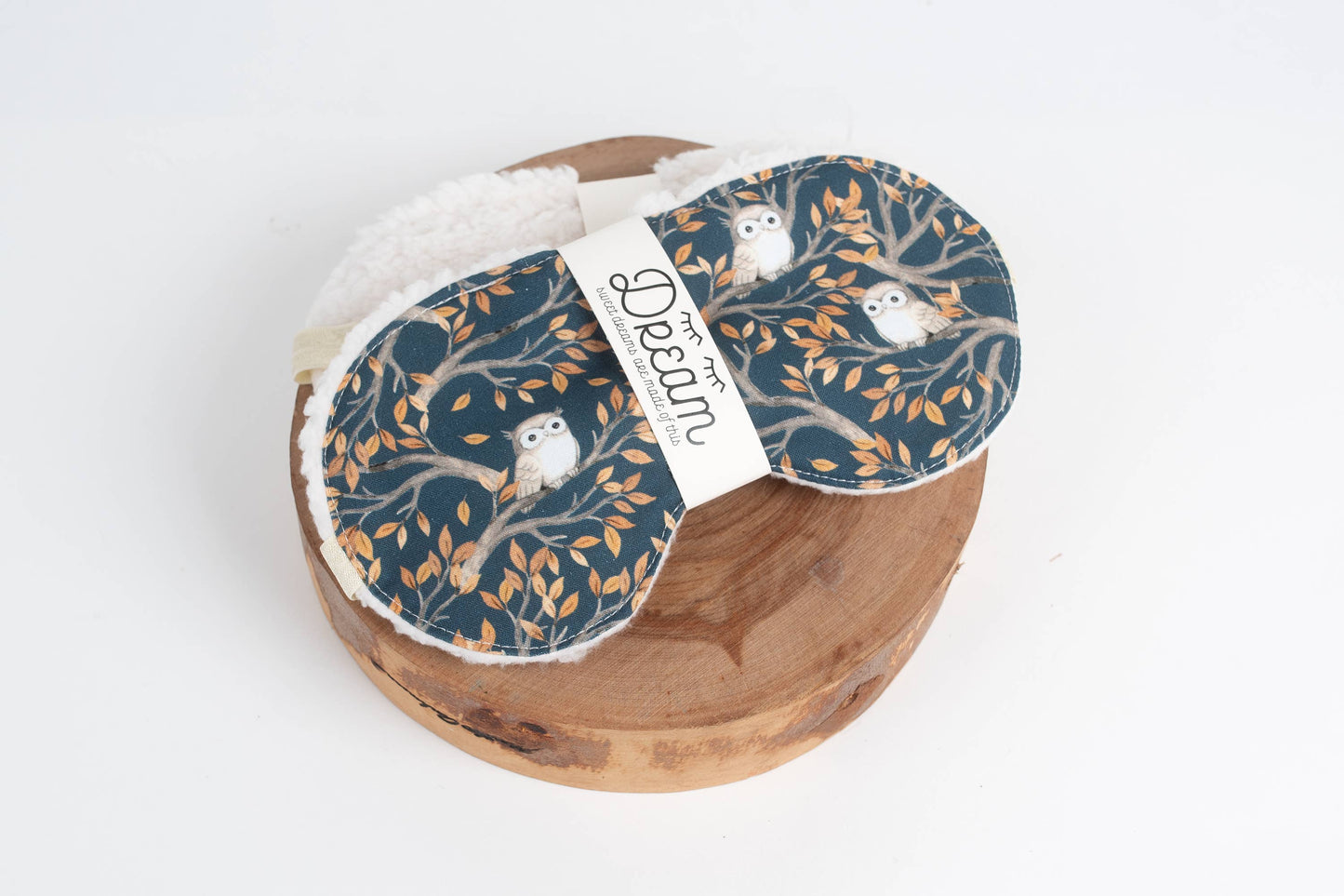Sweet Dreams Night Owl holiday sleep mask with owl and tree print on cotton fabric, displayed on a wooden base with soft minky backing.