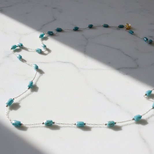 Blue Glass Beaded Chain Necklace on marble surface