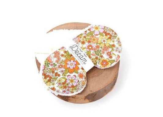 Groovy Sleep Mask - 100% cotton sleep mask with retro floral print, displayed on a wooden base. Soft minky backing for comfort.