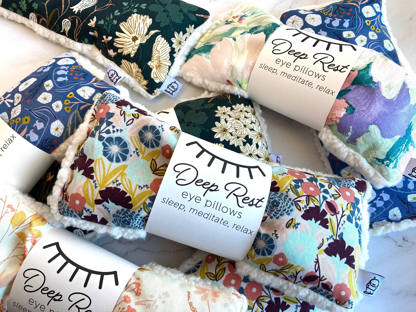 Assorted Deep Rest weighted eye pillows featuring Emerald and other floral prints, ideal for stress relief, sleep, and meditation.