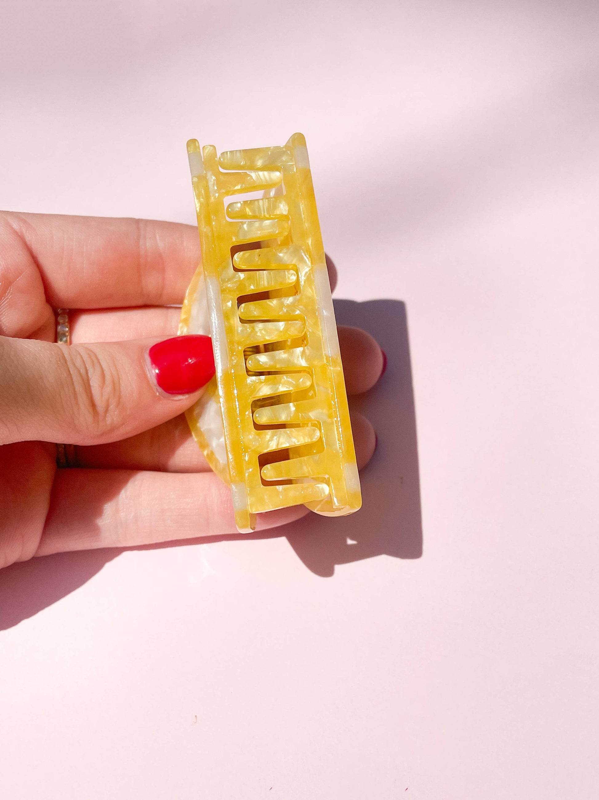 Side view of the Sunshine Yellow Lemon Claw Hair Clip held in hand, showcasing durable acetate teeth for secure hair grip.
