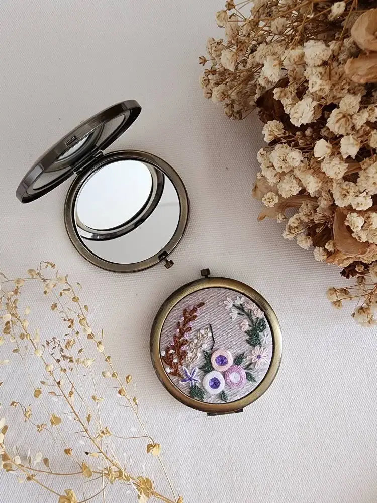 Sophia Collection compact mirror with purple and white floral embroidery, crafted for beauty and gifting purposes.