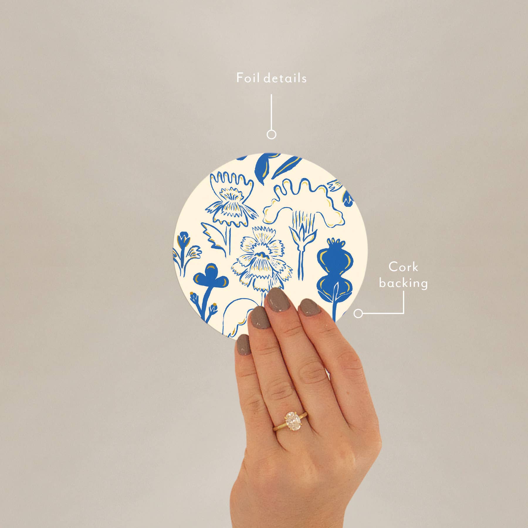 Hand holding corked-backed coaster with blue floral print and foil details, ideal for gifting or everyday use.