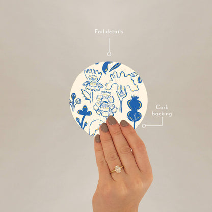 Hand holding corked-backed coaster with blue floral print and foil details, ideal for gifting or everyday use.