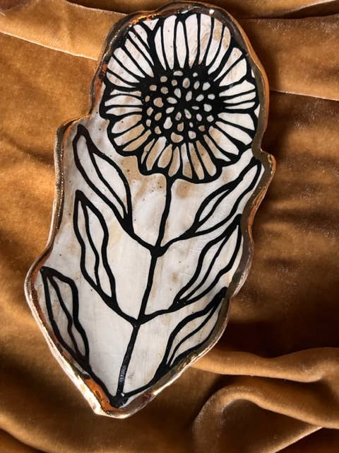 Single 5" handmade floral shaped 22K ceramic catchall jewelry dish featuring a bold black flower and leaf design on a velvet background.