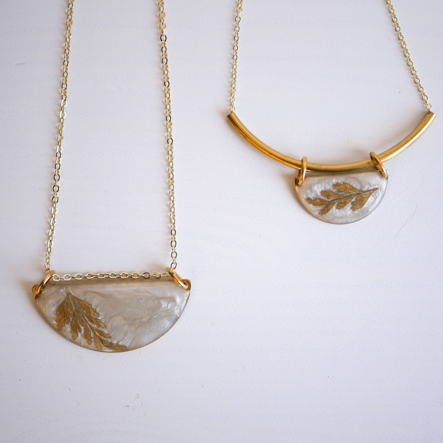 Midas Collection Necklaces featuring two classic pendant styles with gold fern designs on resin, suspended on delicate gold chains.