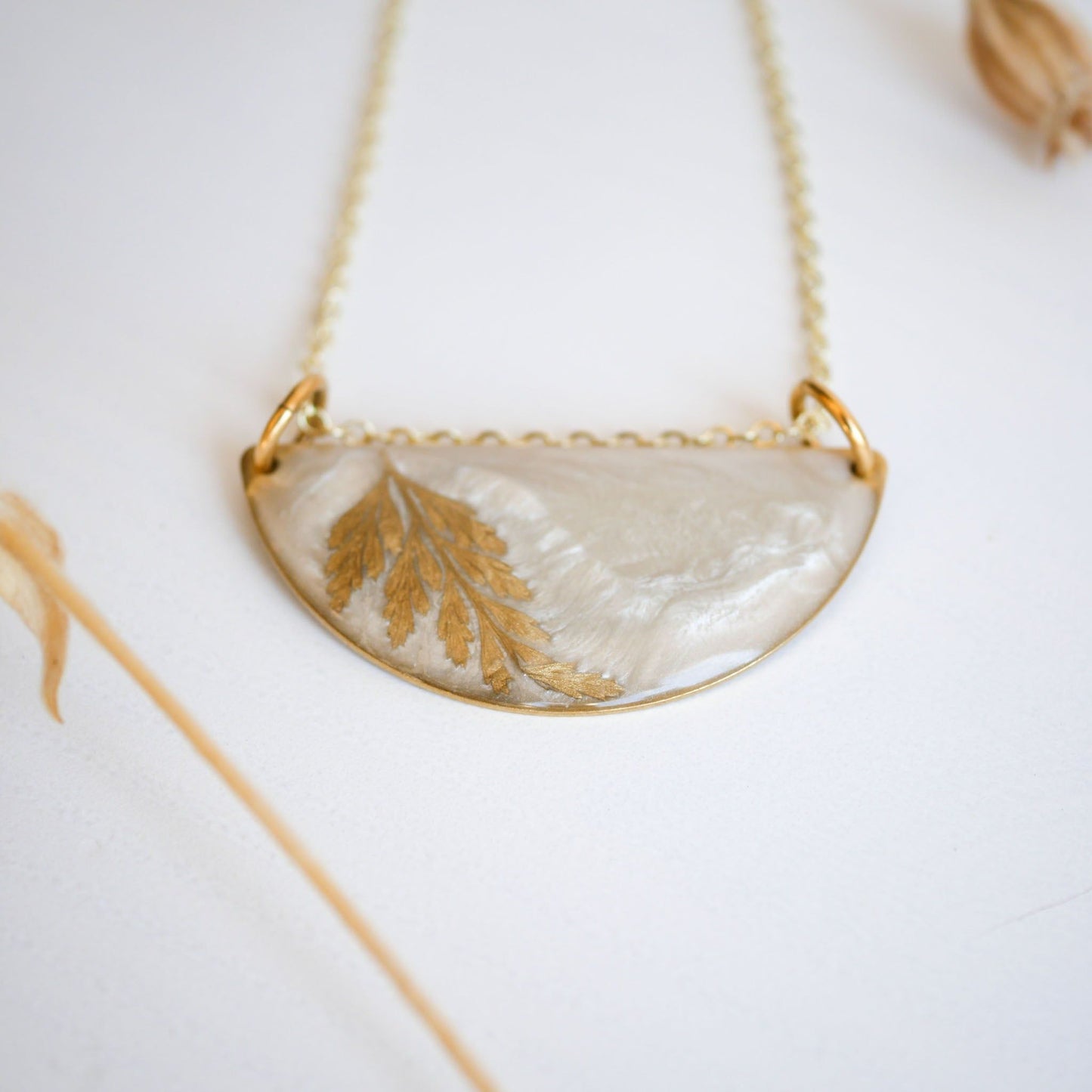 Detailed view of Midas Collection Necklace with a golden fern leaf in resin, highlighting its handcrafted, symbolic design on a gold chain.