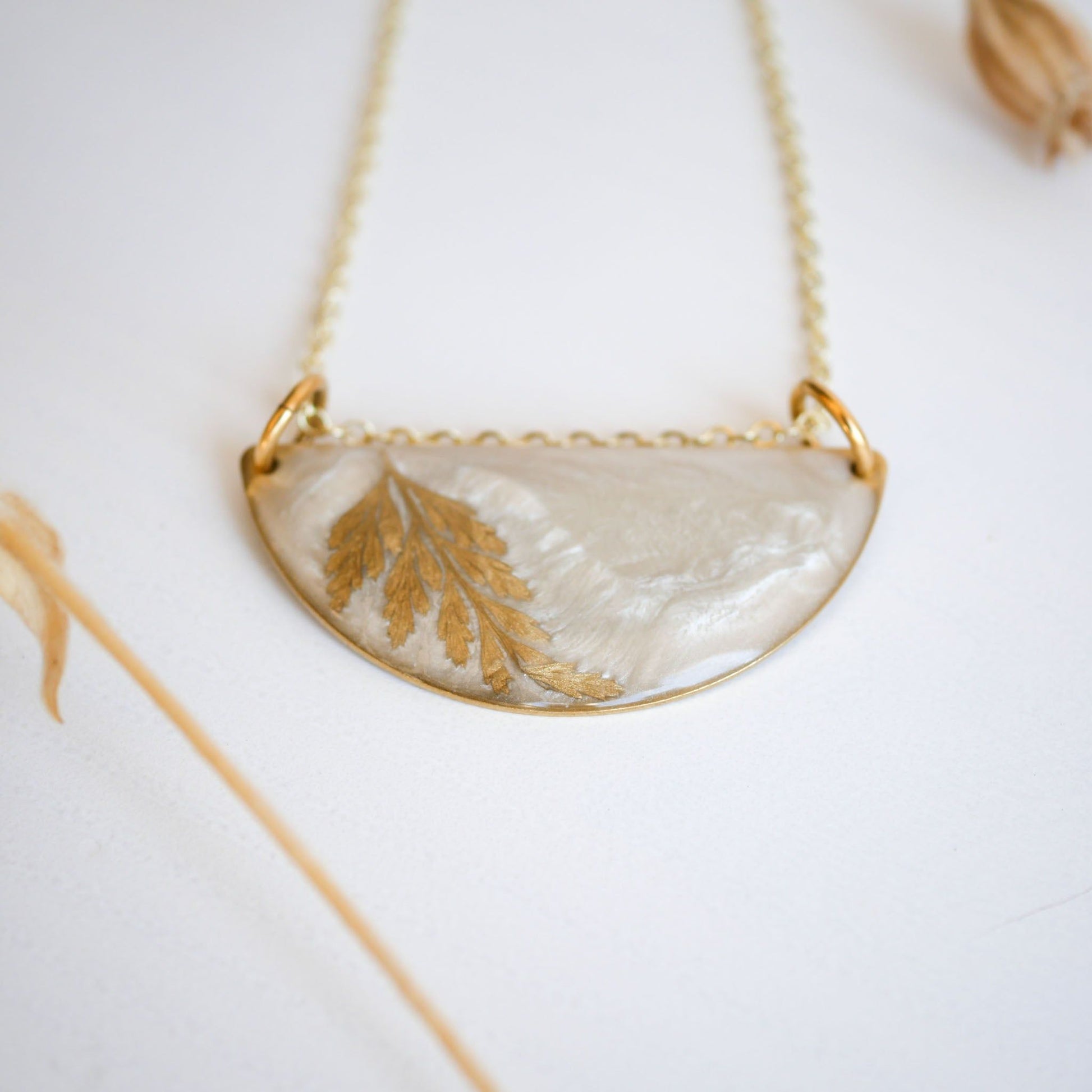 Detailed view of Midas Collection Necklace with a golden fern leaf in resin, highlighting its handcrafted, symbolic design on a gold chain.