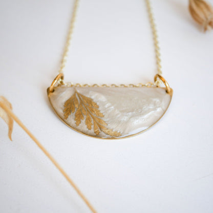 Detailed view of Midas Collection Necklace with a golden fern leaf in resin, highlighting its handcrafted, symbolic design on a gold chain.