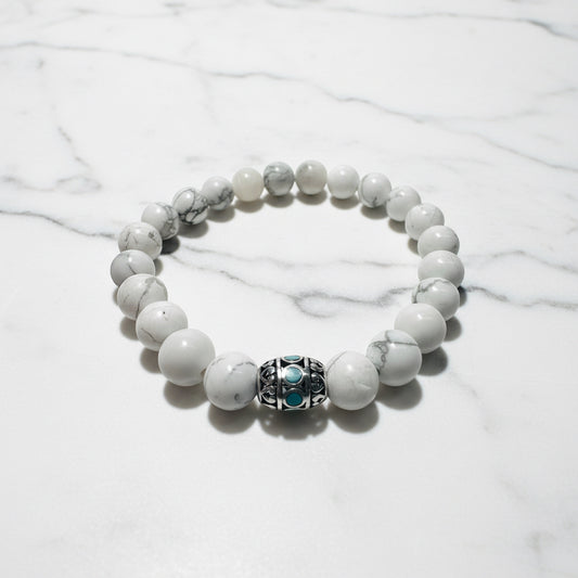 White gemstone beaded stretch bracelet with decorative silver and turquoise bead