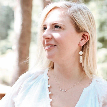 Woman wearing Midas Deco Earrings - Art Dangle, styled with a white blouse and personalized necklace, perfect for gifting or special occasions.