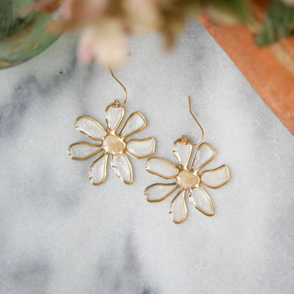 Close-up of peach-centered daisy stained glass earrings with gold trim. Lightweight summer accessory, available at Seed&SoilShop.