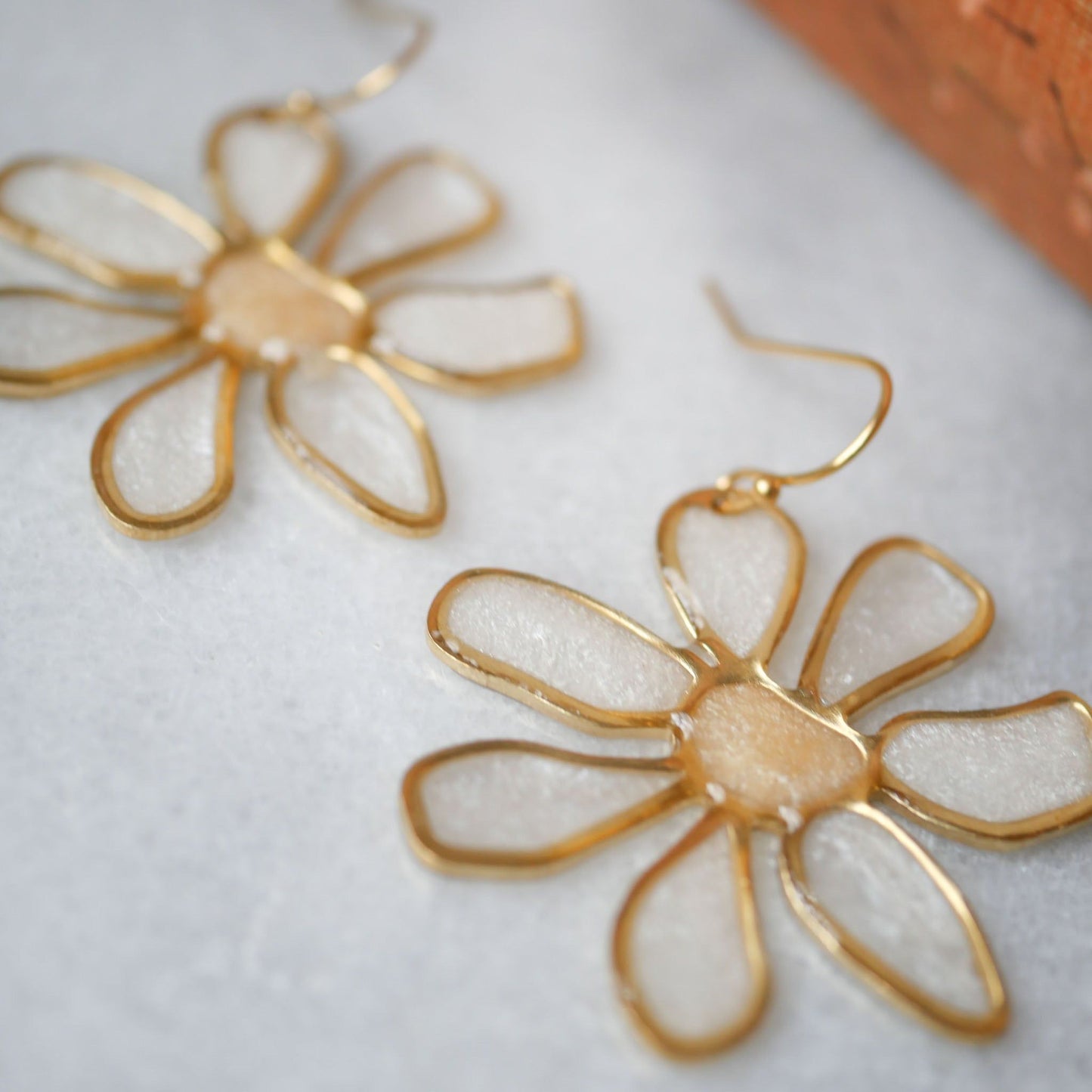 Detailed view of peach daisy stained glass earrings showing translucent petals and gold edges. Perfect summer accessory, shop now.