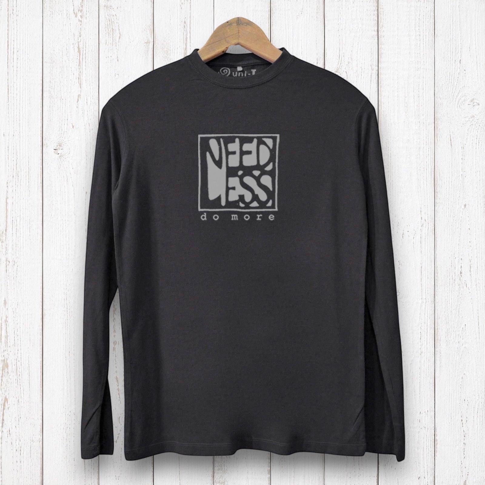 Uni-T black long sleeve bamboo graphic tee with Need Less Do More typography on a white wood background
