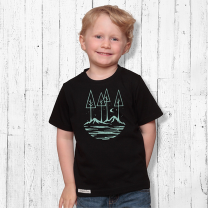 Young boy wearing a black Uni-T organic cotton t-shirt with a light blue nature graphic of trees, moon, and stars.