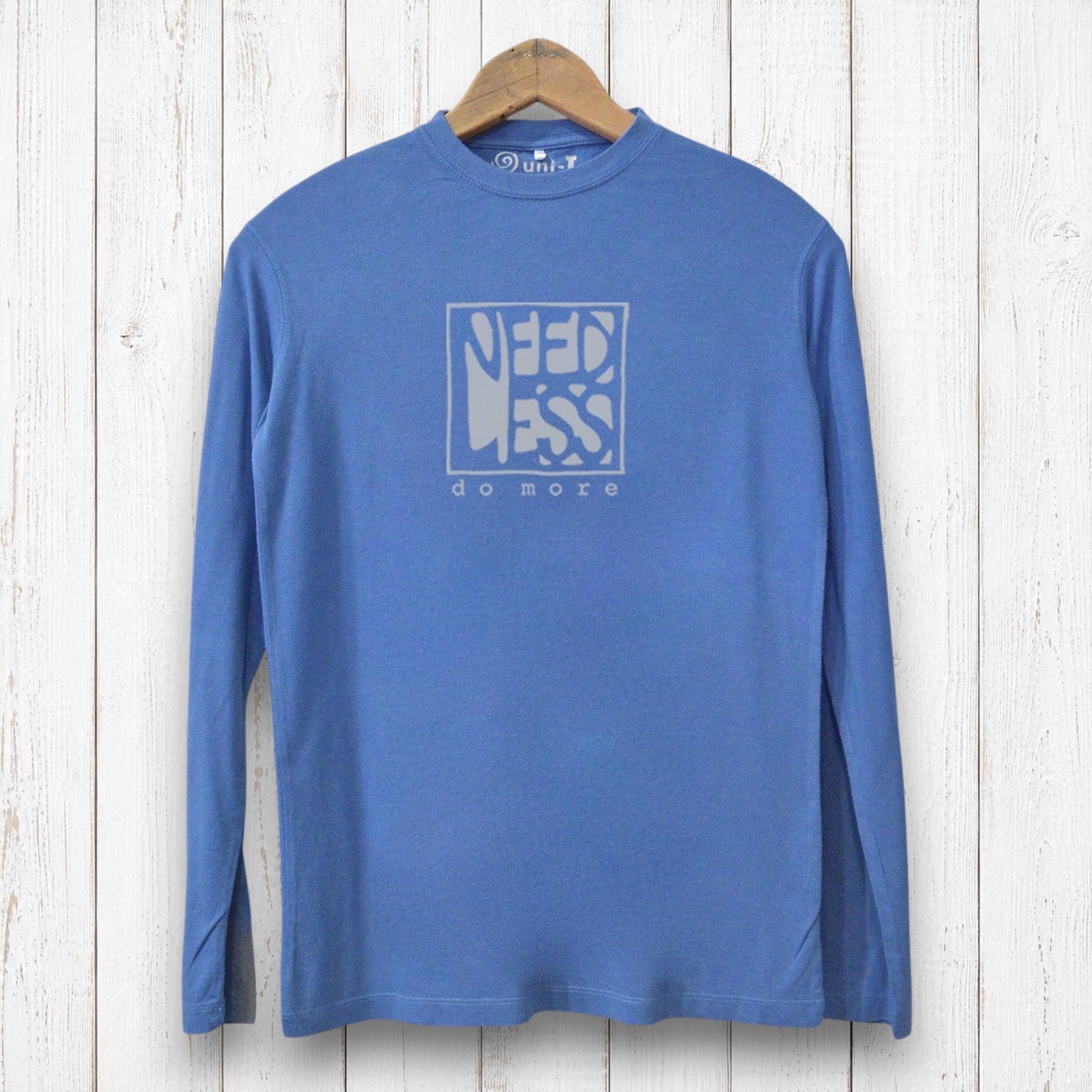 Uni-T blue long sleeve bamboo and organic cotton graphic tee featuring Need Less Do More typography on a wood background