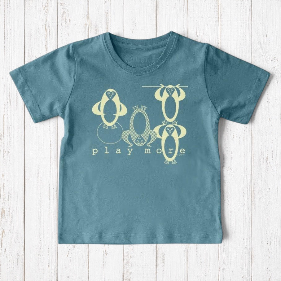 Uni-T kids organic cotton t-shirt in blue featuring a whimsical hand-illustrated penguin graphic and Play More text.