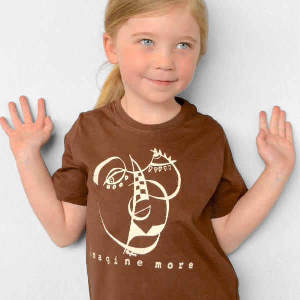Young girl wearing a brown Uni-T organic cotton t-shirt with a white hand-drawn Imagine More artistic graphic print.