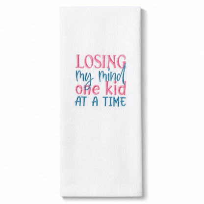 Uni-T white flour sack kitchen towel with pink and blue embroidered text reading Losing my mind one kid at a time
