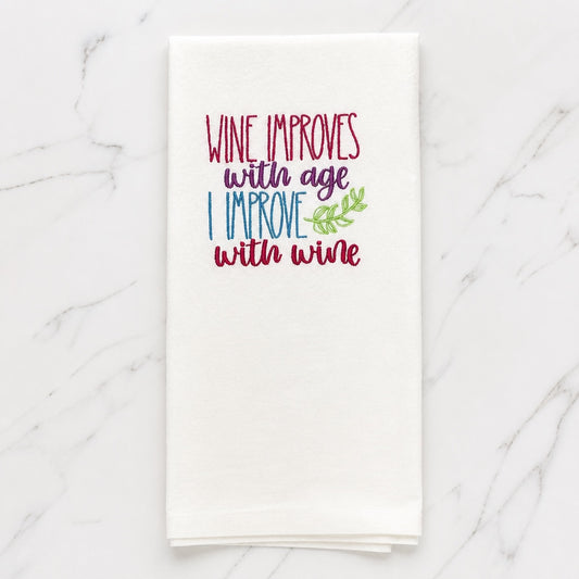 Uni-T white flour sack towel with colorful embroidered text Wine improves with age I improve with wine