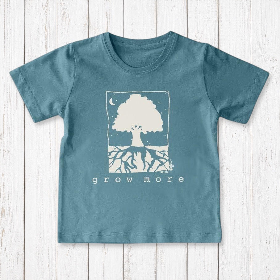 Uni-T kids organic cotton t-shirt in blue featuring a white hand-illustrated Grow More tree graphic on a wood background