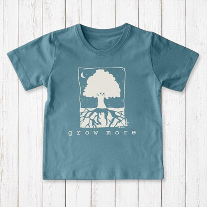 Uni-T kids organic cotton t-shirt in blue featuring a white hand-illustrated Grow More tree graphic on a wood background