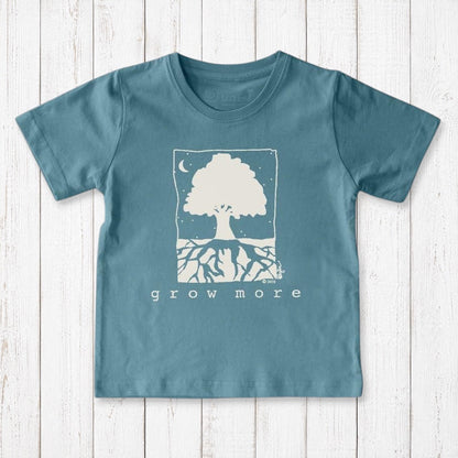 Uni-T kids organic cotton t-shirt in blue featuring a white hand-illustrated Grow More tree graphic on a wood background