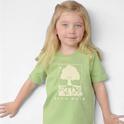 Young girl wearing a light green Uni-T organic cotton t-shirt with a whimsical Grow More tree graphic illustration.