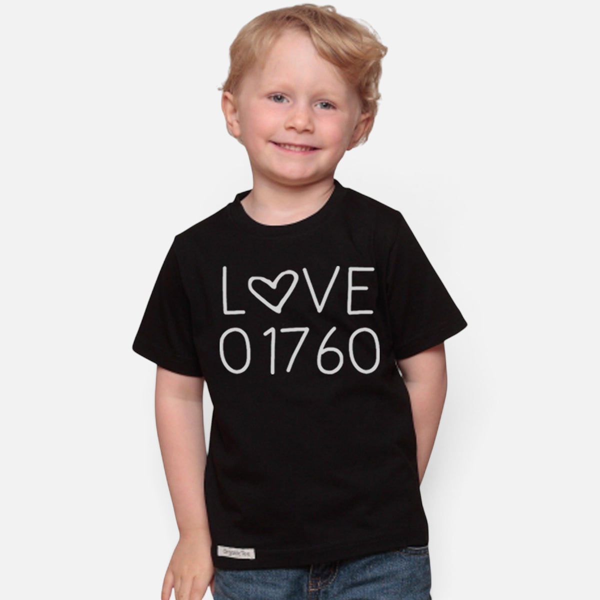 Uni-T kids black organic cotton t-shirt featuring a white hand-drawn Love 01760 graphic worn by a smiling child