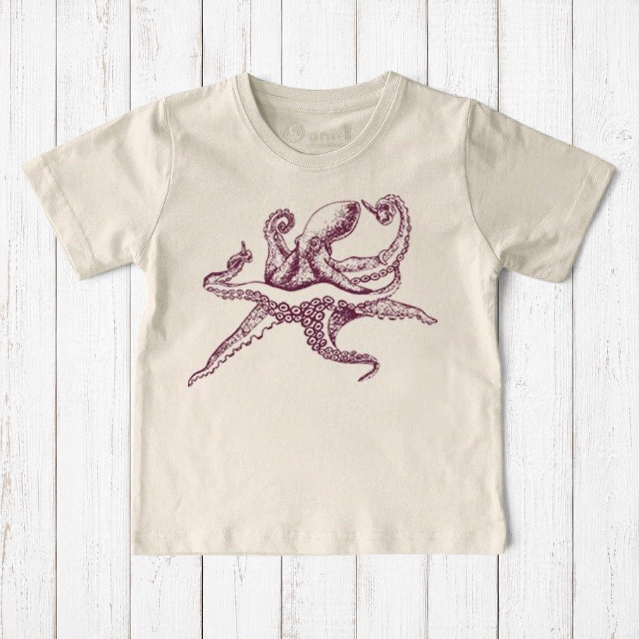 Uni-T kids organic cotton t-shirt in cream featuring a hand-illustrated purple octopus graphic on a wooden background