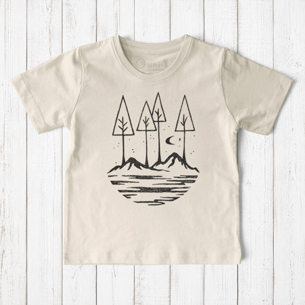 Uni-T kids organic cotton t-shirt in cream featuring a hand-drawn black nature graphic of trees, mountains, and moon.