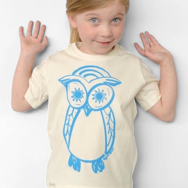 Young girl wearing a cream-colored Uni-T organic cotton t-shirt featuring a blue hand-illustrated owl graphic.