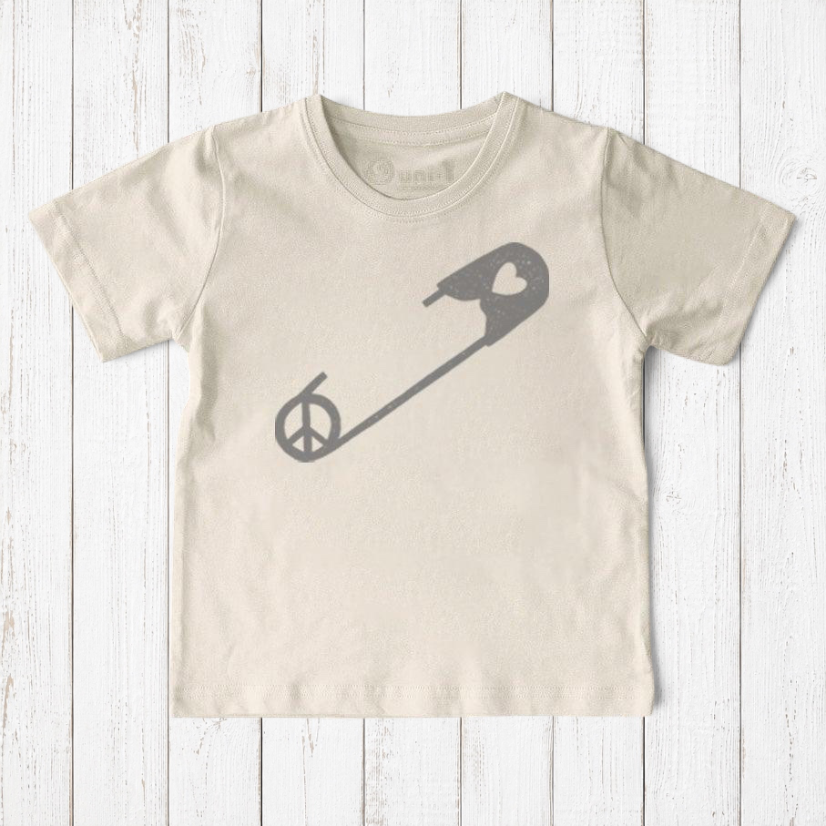 Uni-T kids organic cotton t-shirt in cream with a grey safety pin graphic featuring a peace sign symbol