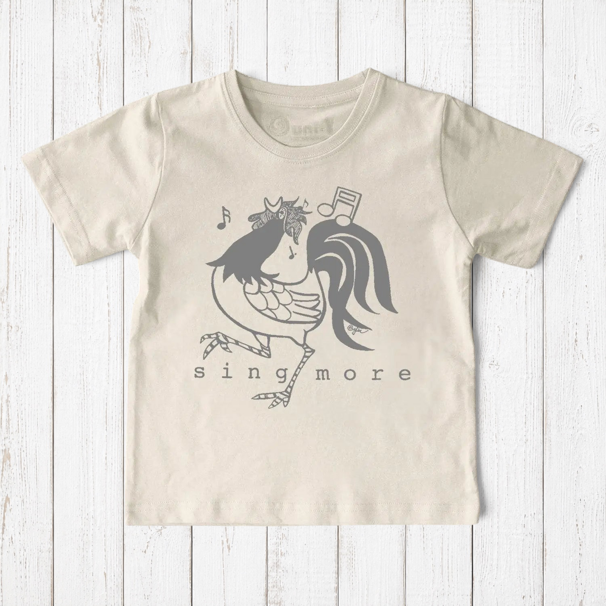 Uni-T kids organic cotton t-shirt in cream featuring a hand-illustrated grey rooster graphic with musical notes.