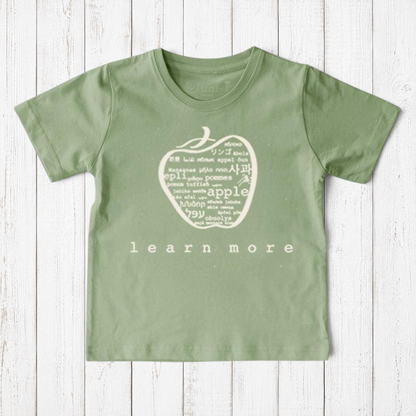 Uni-T kids sage green organic cotton t-shirt featuring a white hand-illustrated apple graphic with multilingual text.
