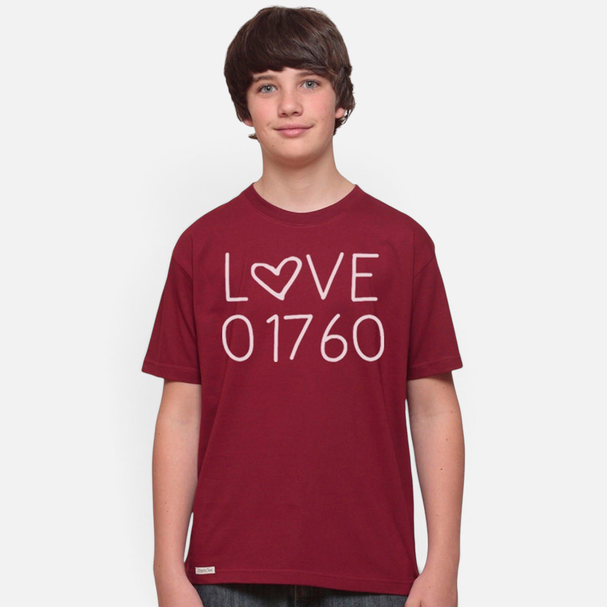 A young boy wearing a maroon Uni-T organic cotton t-shirt with a white Love 01760 graphic print.
