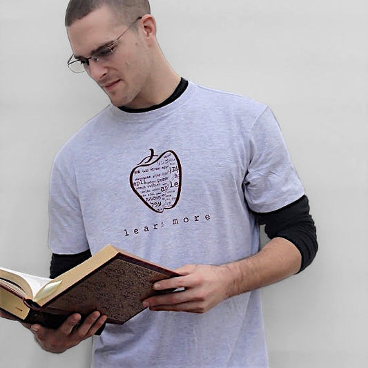 Uni-T men's grey bamboo graphic t-shirt featuring a multilingual apple design, worn by a man reading a book.