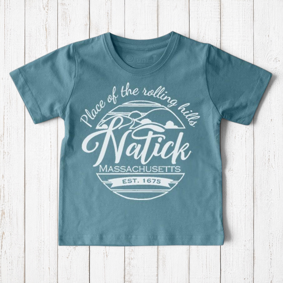 Uni-T kids organic cotton t-shirt in dusty blue with a white Natick Massachusetts circle logo graphic design.