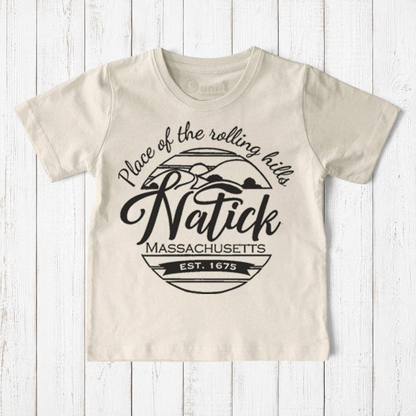 Uni-T kids organic cotton t-shirt in cream featuring a black Natick Massachusetts circle logo graphic design