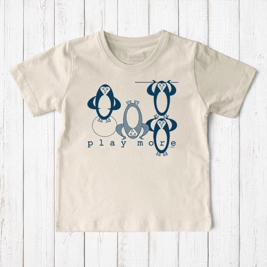 Uni-T kids organic cotton t-shirt in cream with a blue hand-illustrated penguin graphic and Play More text