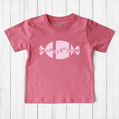 Uni-T pink organic cotton kids t-shirt featuring a white Candytarian candy graphic print on a rustic wood background