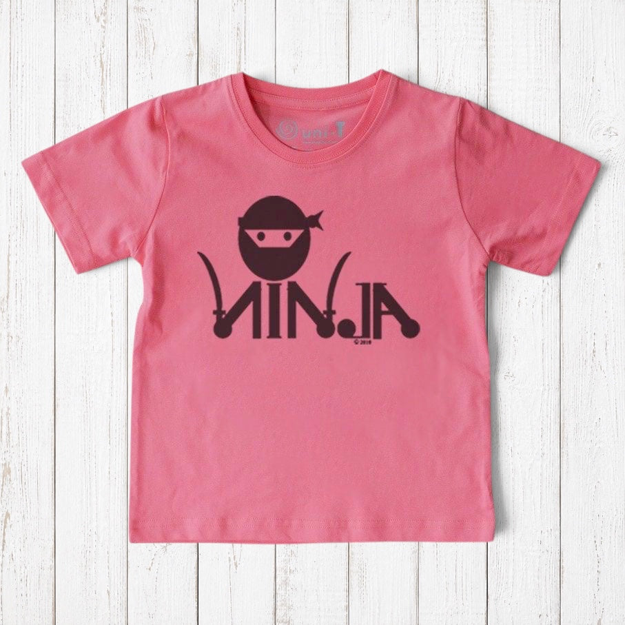 Uni-T pink organic cotton kids t-shirt featuring a black ninja graphic on a white wooden background