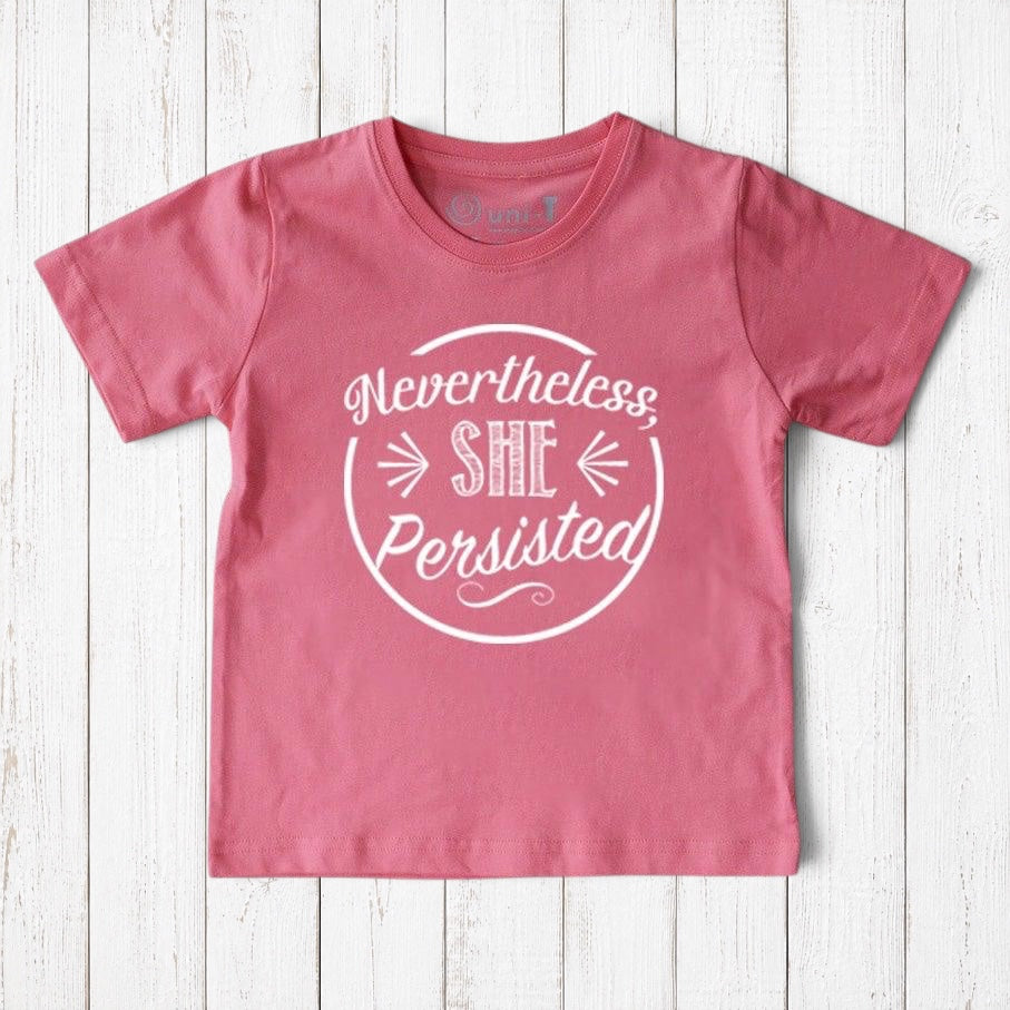 Uni-T kids organic cotton t-shirt in pink with white Nevertheless She Persisted graphic print on a wooden background
