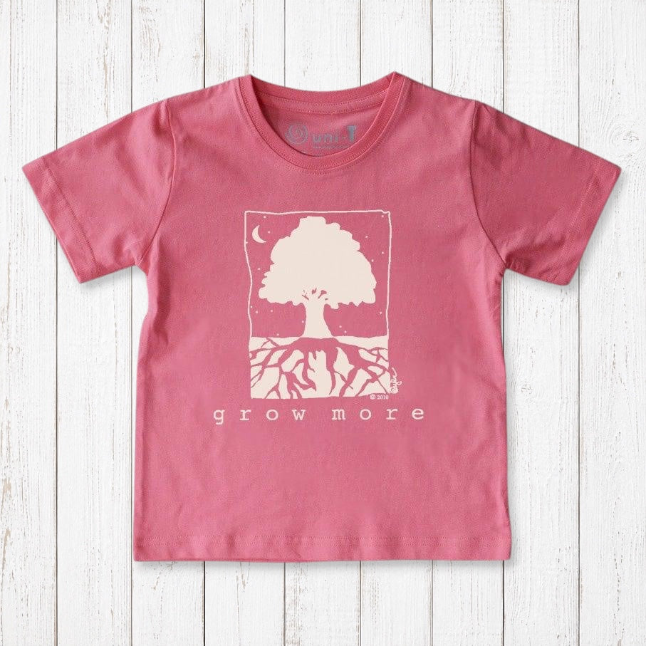 Uni-T kids pink organic cotton t-shirt featuring a white Grow More tree illustration on a rustic wooden background.