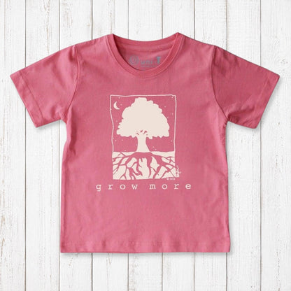 Uni-T kids pink organic cotton t-shirt featuring a white Grow More tree illustration on a rustic wooden background.