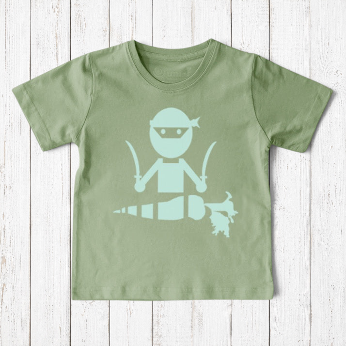 Uni-T organic cotton kids t-shirt in sage green featuring a hand-illustrated ninja graphic chopping a carrot.