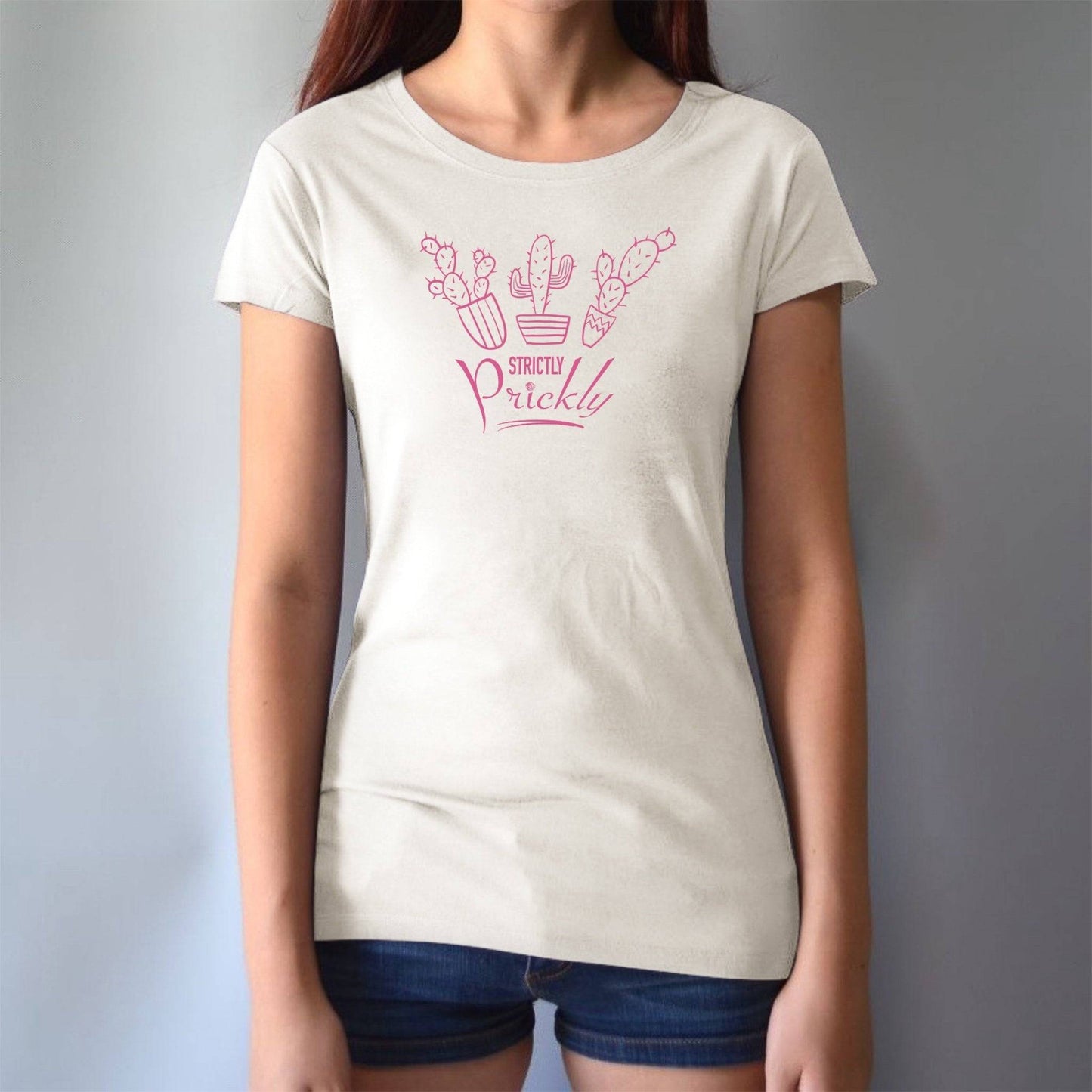 Model wearing cream cactus t-shirt for women with pink 'Strictly Prickly' print. Organic cotton and bamboo blend for eco-conscious style.