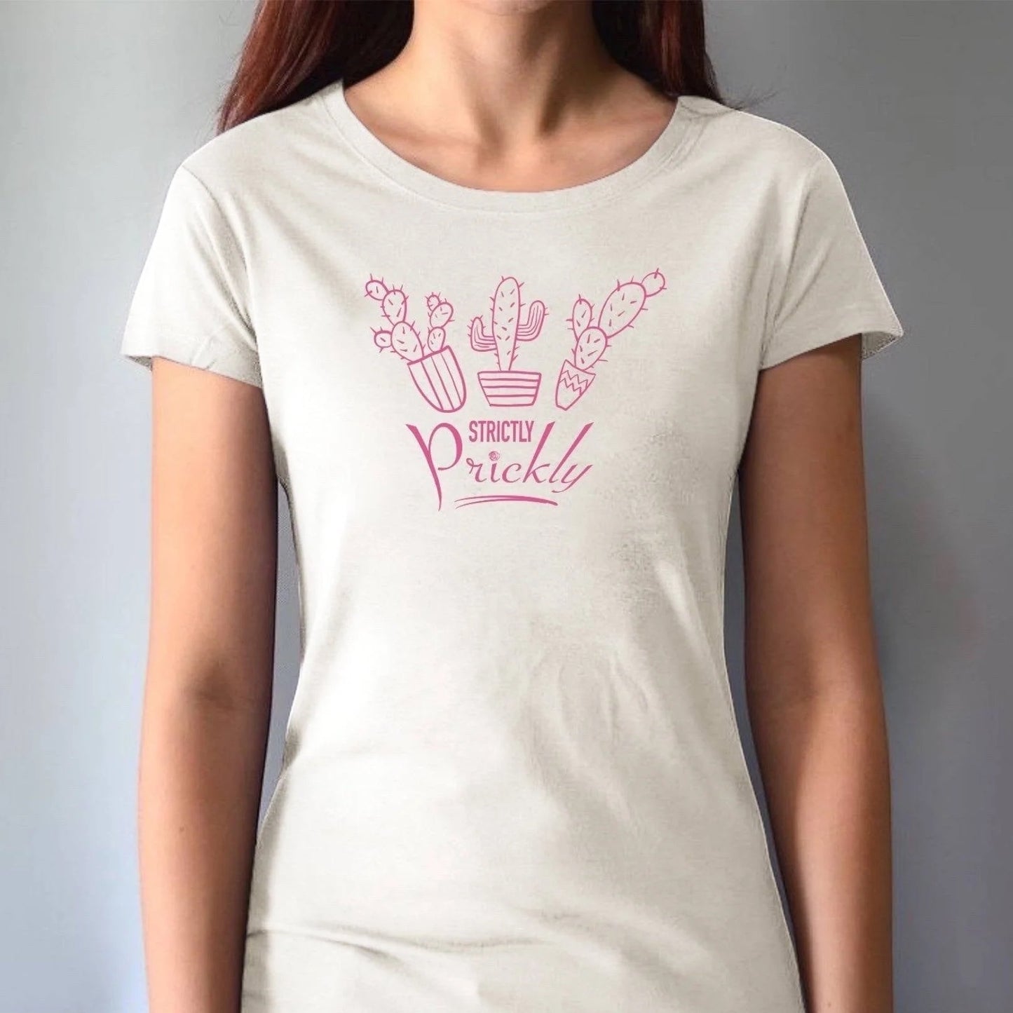 Model wearing cream cactus t-shirt for women with pink 'Strictly Prickly' print. Organic cotton and bamboo blend for eco-conscious style.